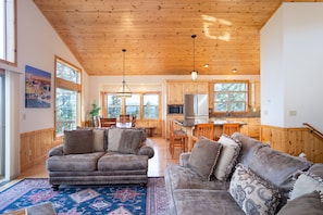 Easily access the living, dining and kitchen area from the open grand floor plan. The cathedral ceiling and wall of windows throughout this grand room provides incredible views and natural light! A spacious open deck off the living room invites you s