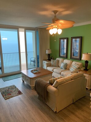 Living room with floor to ceiling balcony windows and doors. 