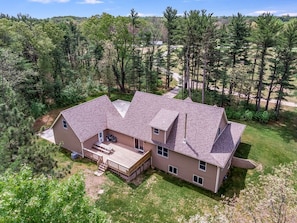 The house is surrounded by woods on all sides- arial view of back of house