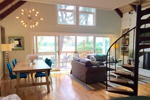 Open concept great room with wide spiral staircase leading to upstairs loft.