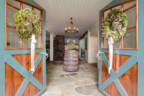 Entry from Barn doors into the stone floored Foyer and Dining area