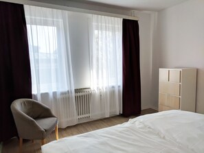 Schlafzimmer mit Kommode und Bad