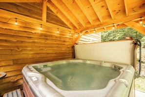 Covered hot tub with privacy fence.