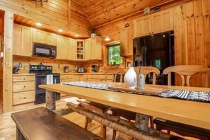 Kitchen & dining area w/ waffle iron, coffee maker, blender, utensils, pans, crockpot, etc