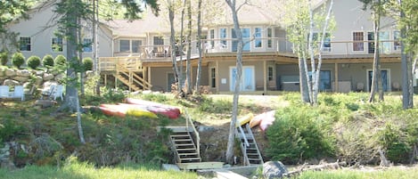 back of home, horseshoe pit , firepit, dock and hot tub