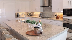 Gather for drinks or snacks as meals are prepared in the well-equipped kitchen