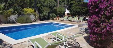 Villa Suro. An aspect of pool and ample patio area with BBQ area in distance.