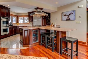 The well-appointed kitchen offers high-end appliances, double ovens, a drip coffee maker, and a spacious breakfast bar that seats 4.