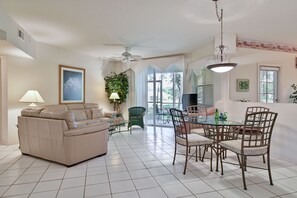 SW4-105 - Comfortable seating and TV in the living. The sliding doors open up to the screened in patio and offers beautiful green view. Breakfast nook off the living