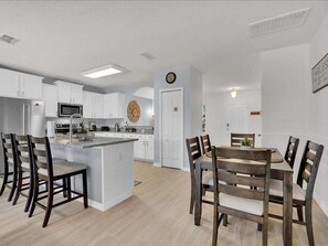 Modern dining area adjacent to a fully-equipped kitchen, perfect for family meals.