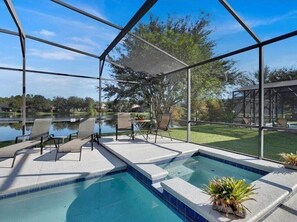 Screened-in pool with a serene lake view, offering ultimate relaxation and privacy.