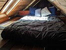 Queen bed in upstairs sleeping loft, beneath skylights
