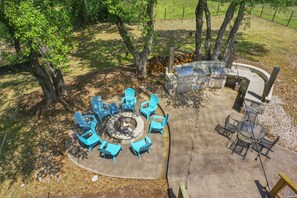 View of the outdoor kitchen and fire pit area from the upstairs balcony.