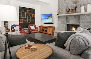 Lots of comfy seating around the large TV and stone fireplace.