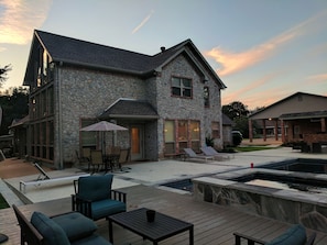 Side of house with pool, hot tub, and decking 