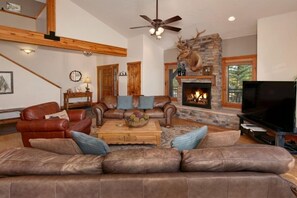 Main level living area with big screen smart TV and gas fireplace.