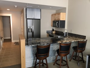 View of kitchen and bar from living room