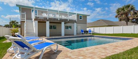 Back view of this home for rent new Smyrna beach with large pool and fenced in backyard.