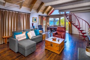 Living room with queen pull out couch, spiral stairway to loft
