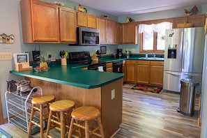 Full kitchen with appliances and cookware.