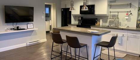 Brand new bar stools, chair and wall-mounted flat screen TV. 