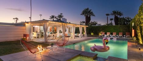 The pool, cabana, hot tub lounge chairs in the evening