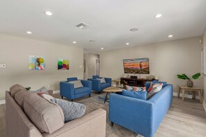 Spacious designer furnished living room featuring a Smart TV, Sound system, and a Pool table for entertainment.