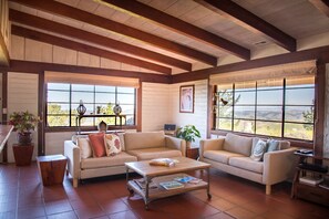 Open beam ceilings & original metal windows add warmth & character to this home