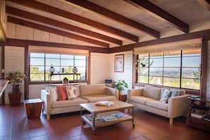 Open beam ceilings & original metal windows add warmth & character to this home