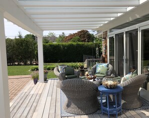 Glass-covered deck makes for lovely lounging & dining, rain and shine.