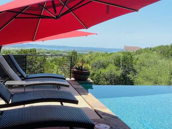 Umbrellas open and shading the loungers by the pool.