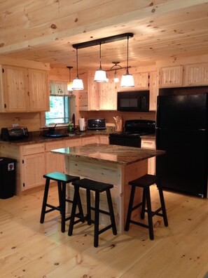 Full kitchen with granite countertops and custom cabinetry with island