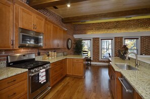 Well stocked, beautifully updated kitchen features upgraded appliances & granit