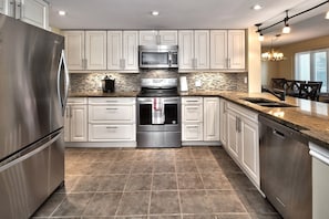 Renovated kitchen has upgraded cabinetry, stainless steel appliances and granite