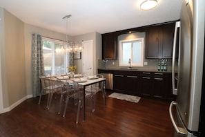 Bright eat in kitchen with stone countertops and stainless steel appliances.