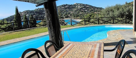 Piscina y comedor con vista al mar