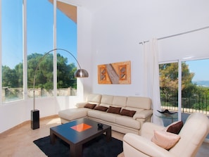 Bright living room with large windows overlooking the garden.