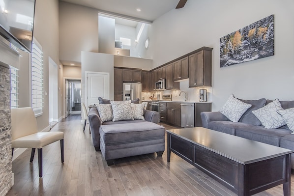 Living Area - Queen size sofa sleeper, fireplace, flat screen TV, and access to private patio.