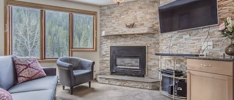 Living Area - Upgraded stone wall behind fireplace and flat screen TV.