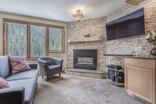 Living Area - Upgraded stone wall behind fireplace and flat screen TV.