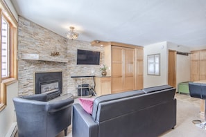 Living Area - Gas fireplace, flat screen TV, and natural lighting.