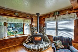 The living room hosts a TV, DVD player and charming stove.