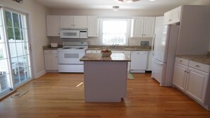 Eat in kitchen with new, white table for four.  Granite counter tops