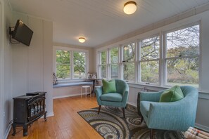 cozy, sunny back porch with flat screen TV, fireplace and window seat