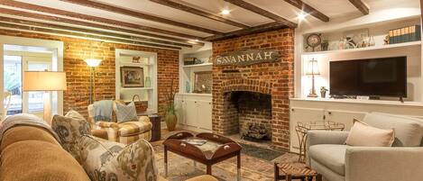 Southern Belle Garden Living Room with exposed beams and exposed brick walls and large Flat Screen TV	