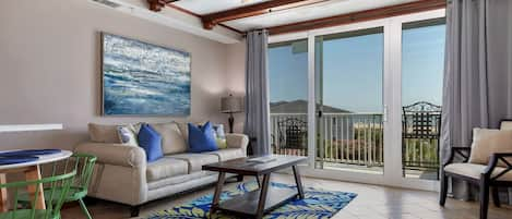 Living room opens to balcony with view of pools and the Atlantic Ocean