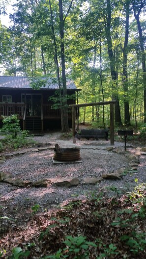 Fire pit, park grill and swing behind cabin.