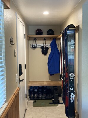 Gear storage with outlet for boot dryers, rack for skis and boards and hooks. 