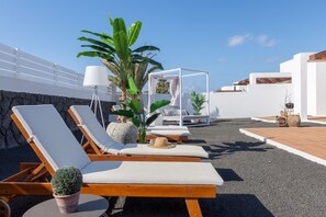 Terrace with sun loungers and Balinese bed.