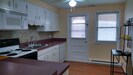 Kitchen with electric stove, dishwasher, refrigerator and pots, pans, dishes etc